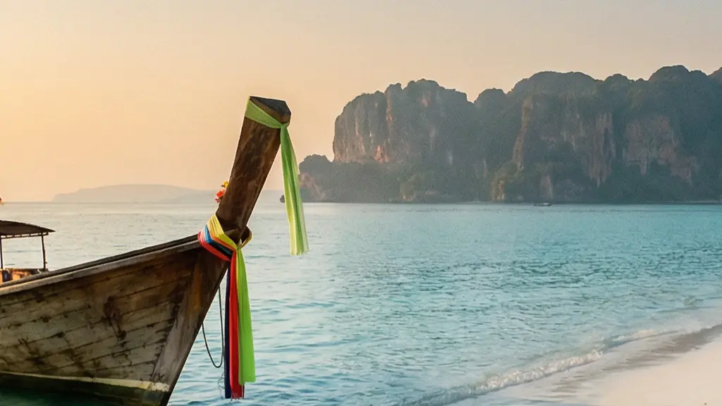 Bateau longtail traditionnel amarré sur une plage turquoise d'une île thaïlandaise, symbolisant les excursions à réserver en avance