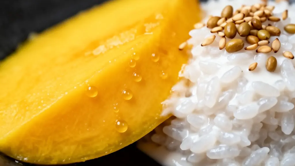 Gros plan sur une mangue mûre et du riz gluant nappé de lait de coco, mettant en valeur les textures.