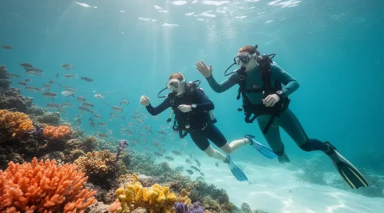 Plongeur débutant explorant un récif corallien tropical aux eaux turquoise, avec un instructeur de plongée à ses côtés dans les eaux limpides de Koh Tao