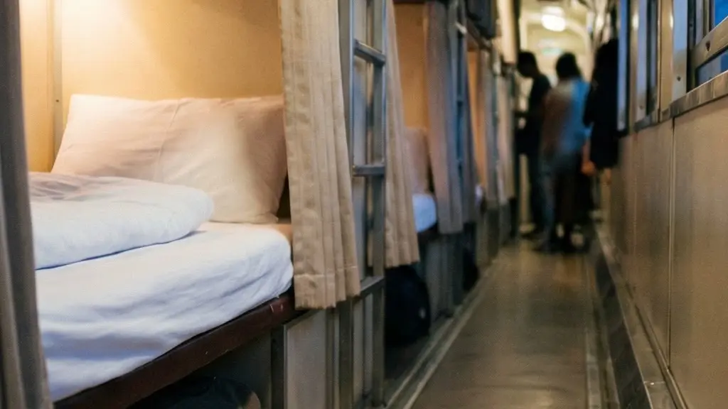 Intérieur réaliste d’un train de nuit en Thaïlande, avec une couchette basse prête pour dormir et un couloir flou en arrière-plan.